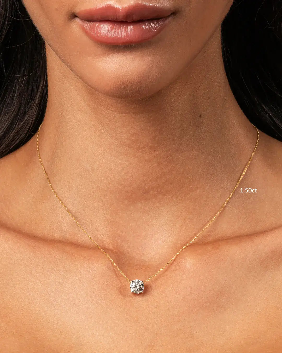 Elegant model showcasing The Floating Diamond Necklace featuring a 1.50ct round brilliant diamond on a fine gold chain.