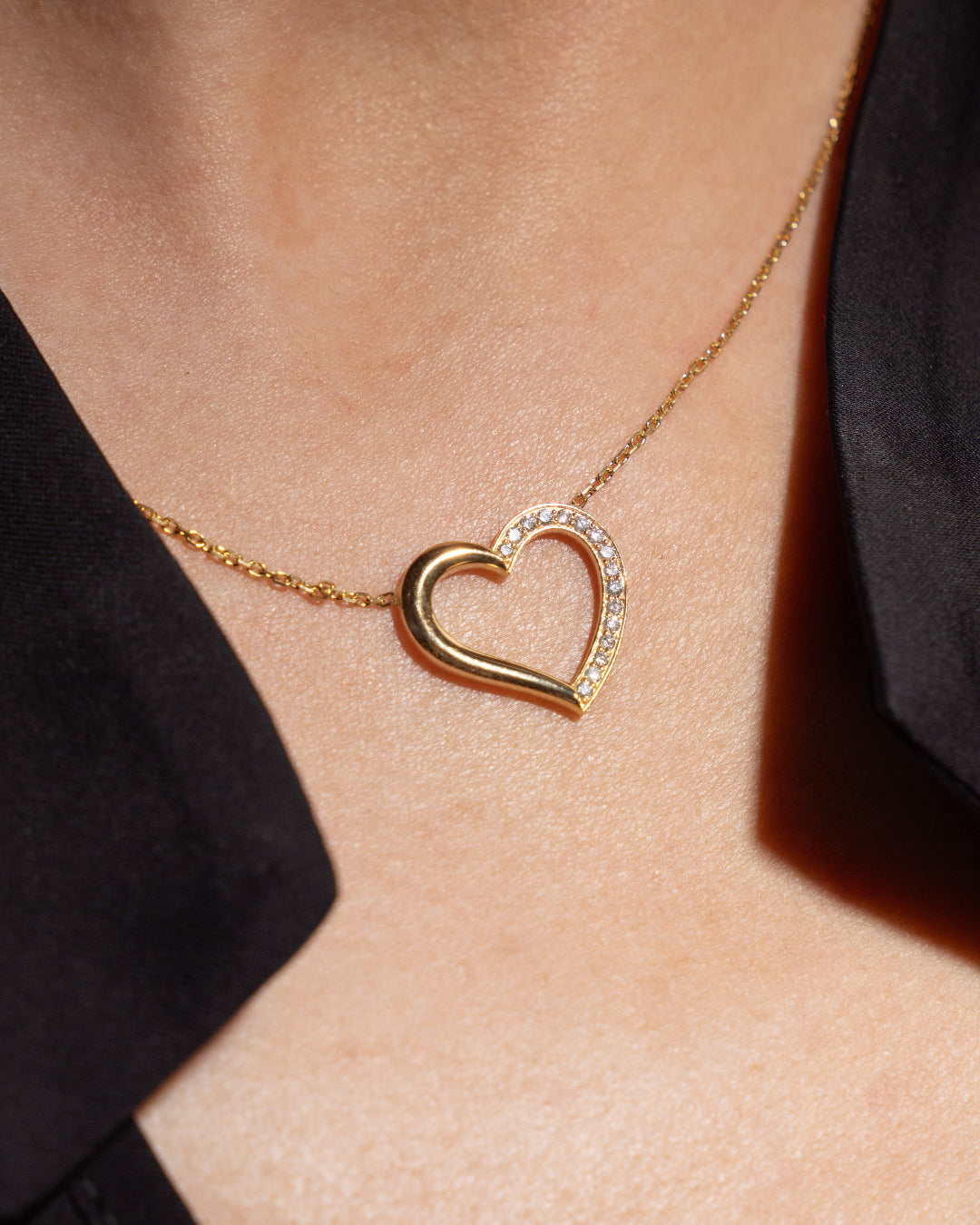 18ct gold heart necklace featuring diamonds, elegant diamond necklace worn elegantly on a model's neck.