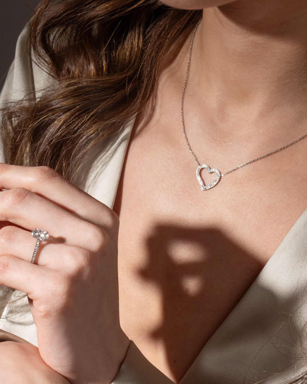 Elegant woman wearing the Amélie diamond necklace in 18ct gold, showcasing a heart pendant with brilliant diamonds.