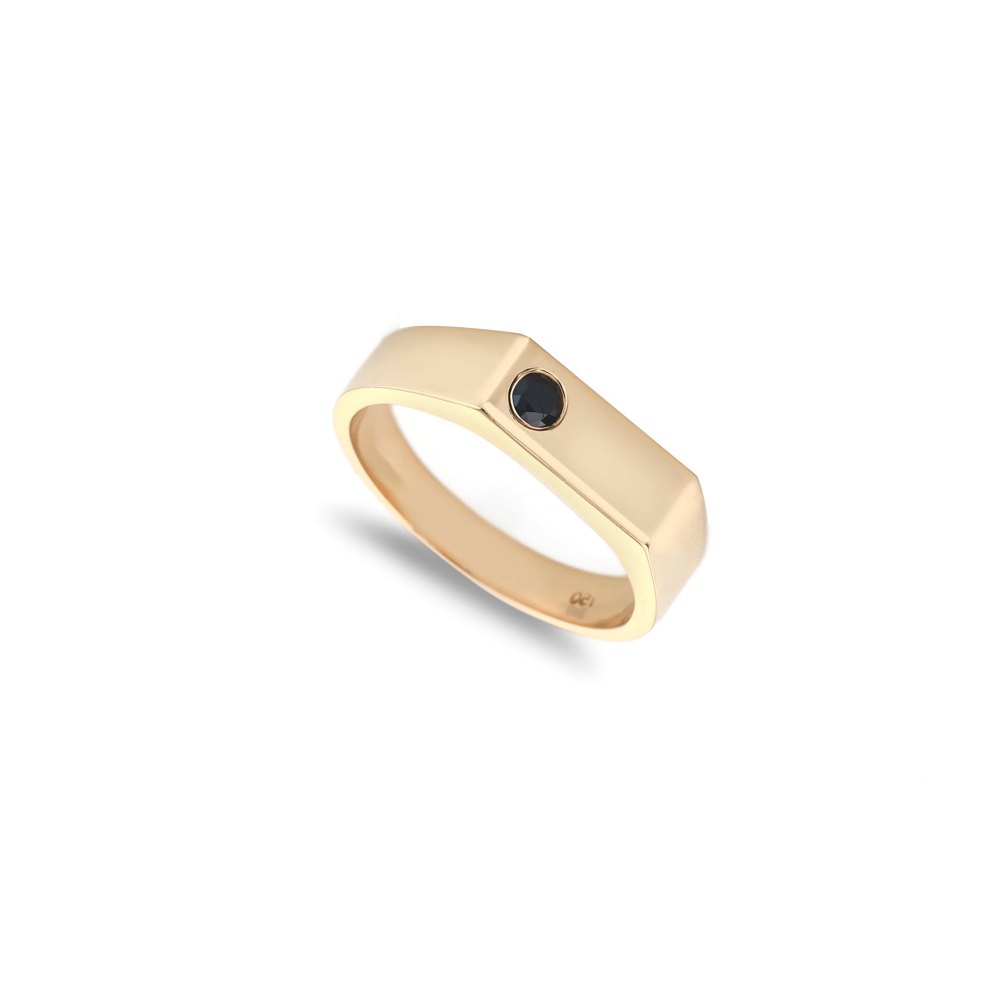 Gold ring with a black gemstone on a white background