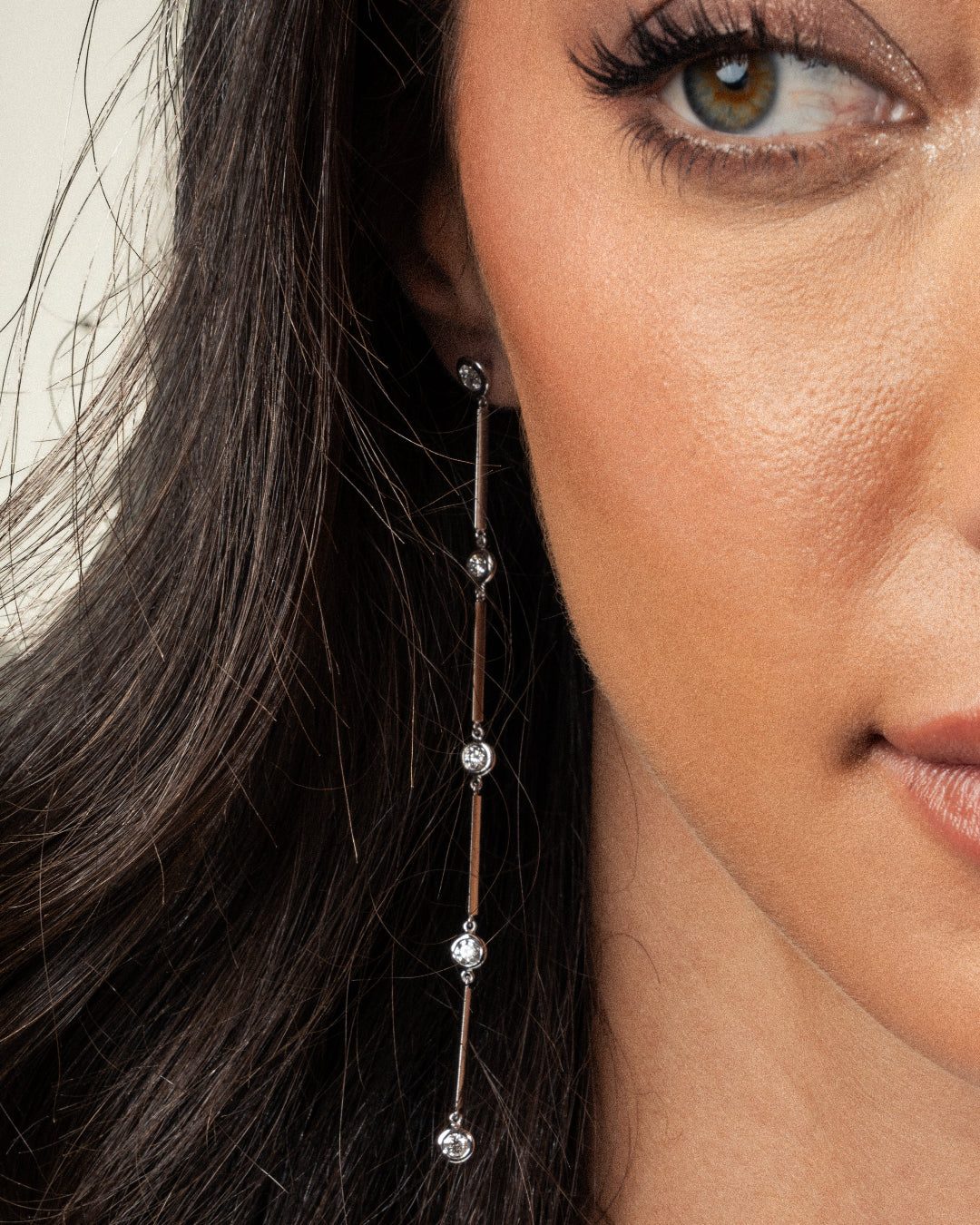 Close-up of a model wearing Cascade Diamond earrings in 18ct white gold with a cascading design.