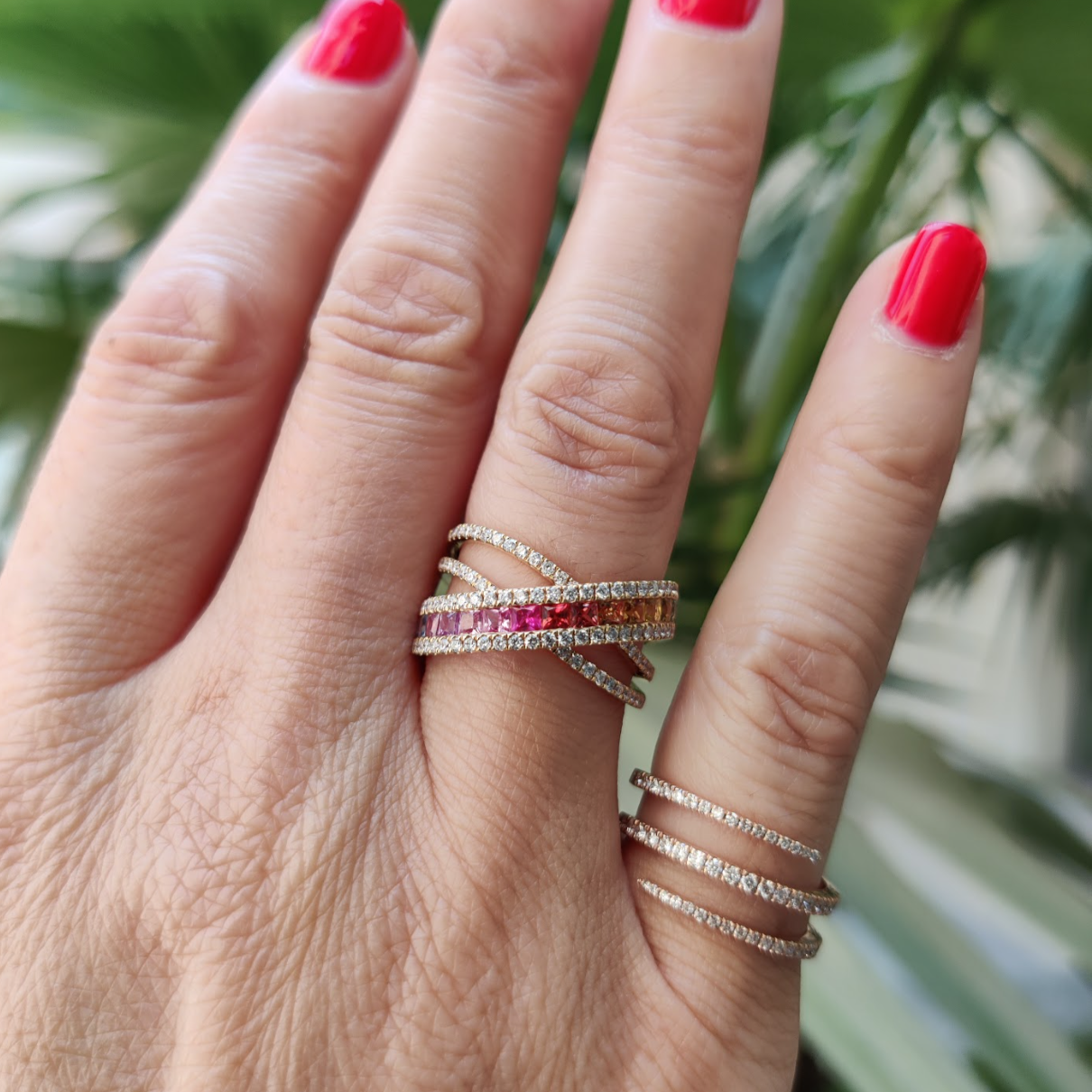 Model wearing Sapphire Criss cross ring featuring fifteen coloured sapphires, and round brilliant diamonds, set in 18ct gold.