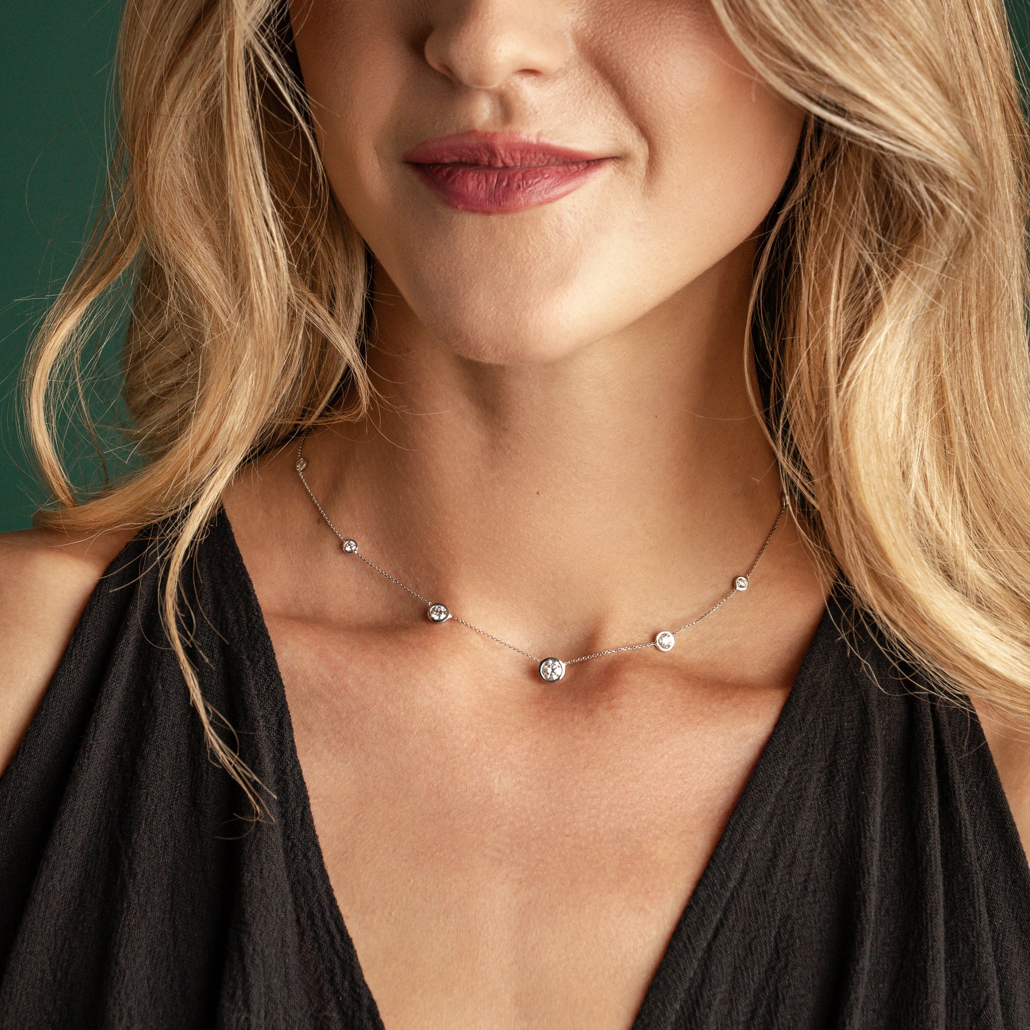 Constellation Necklace - Graduating worn by a model, featuring graduating diamonds in a delicate bezel setting.