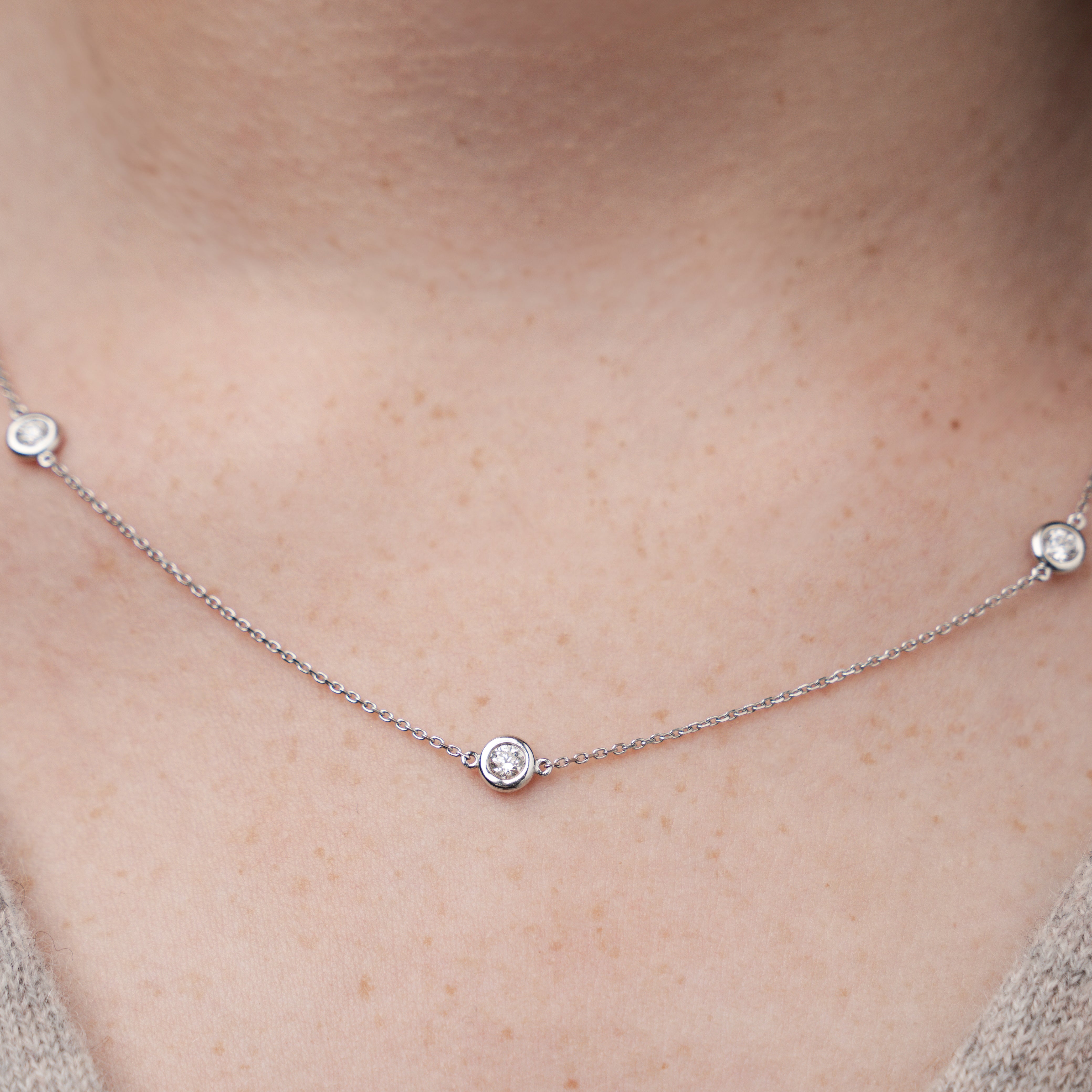 Constellation necklace with small round diamonds on a person's neck