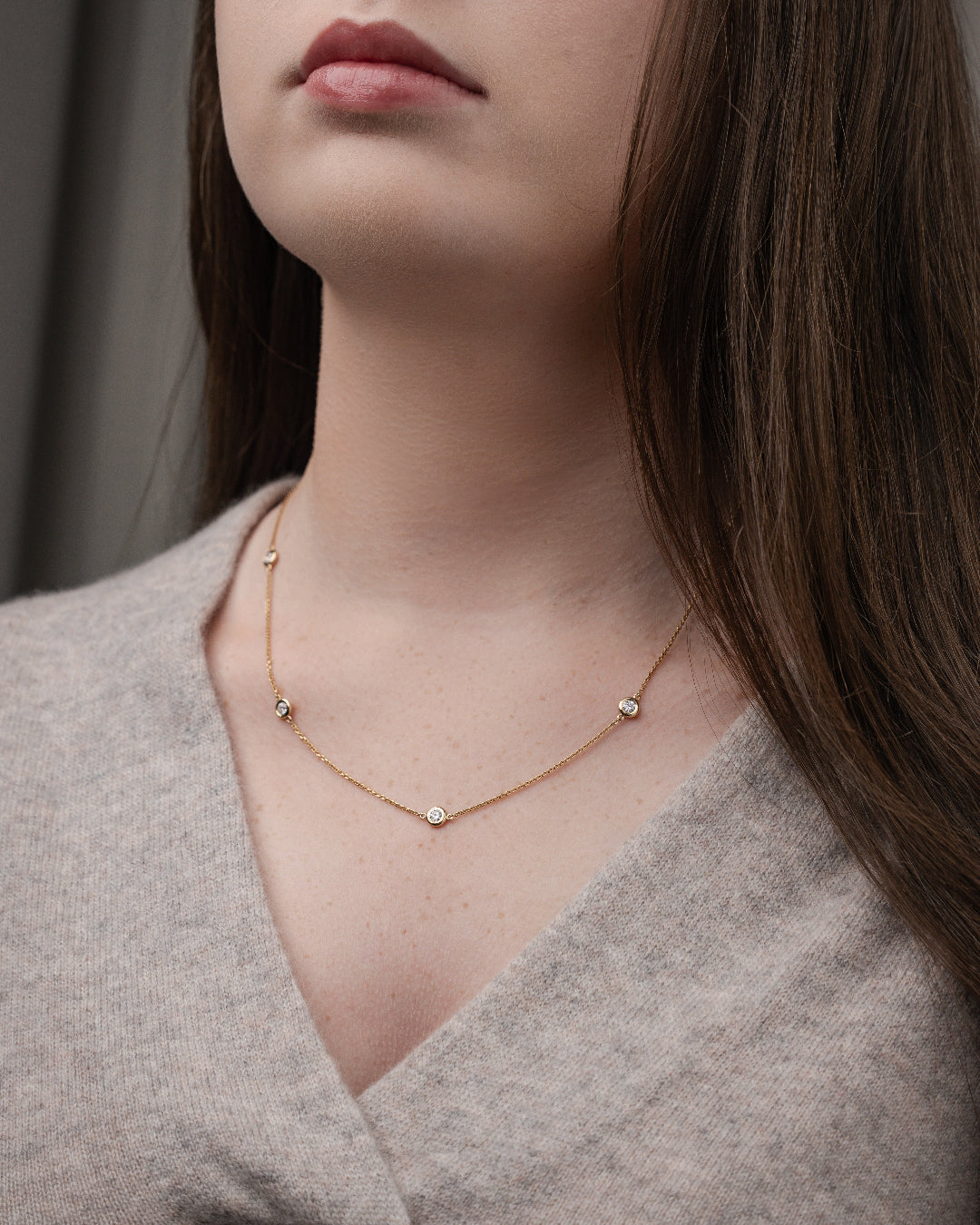 Constellation necklace on a model featuring certified diamonds set in 18ct gold chain, enhancing a feminine style.