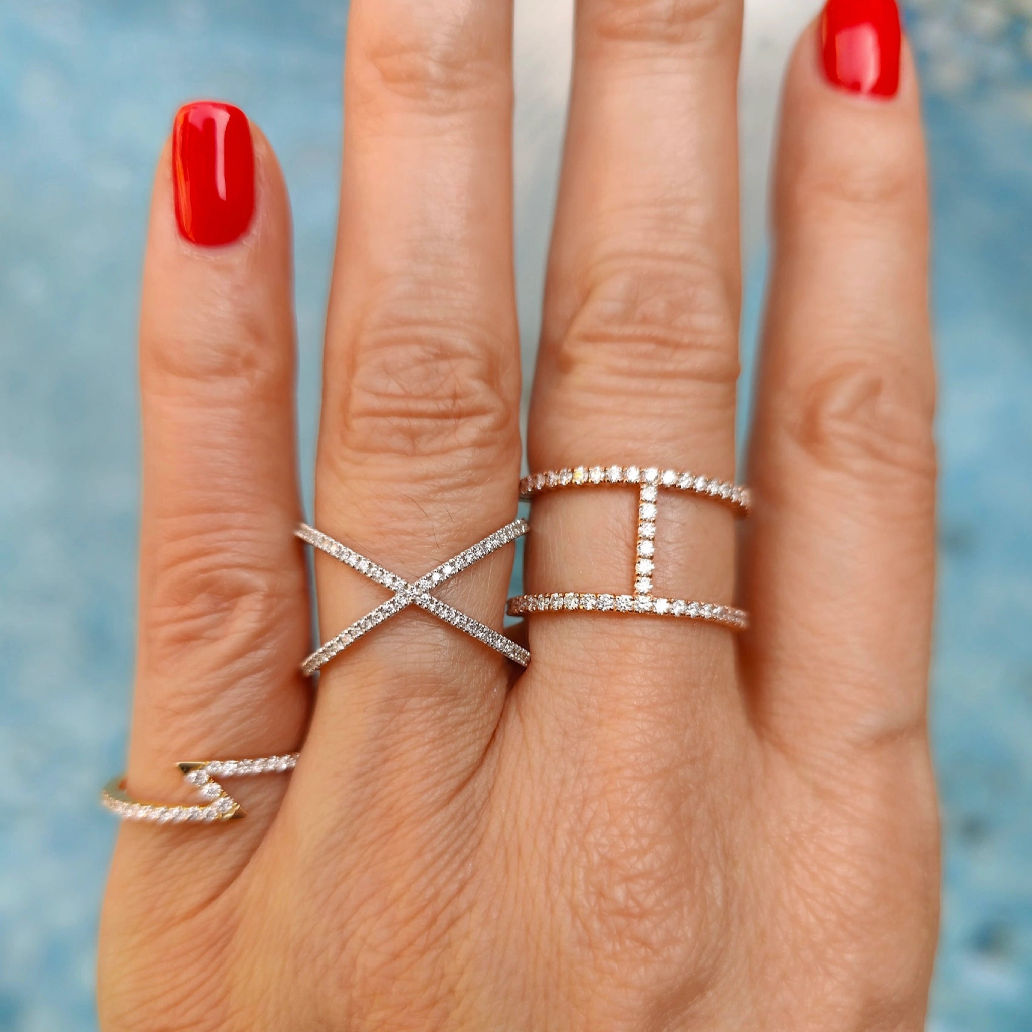 Models wearing diamond criss cross rings white gold colour set in 18ct gold.
