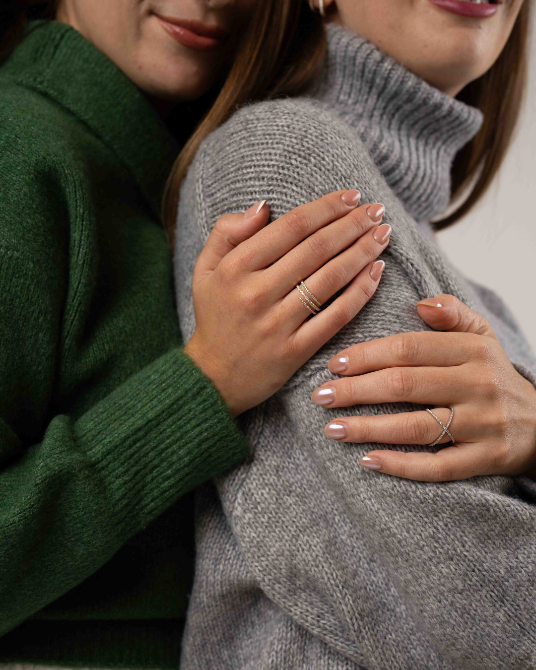 Models wearing ciss-cross rings with round brilliant cut diamonds, white gold colour set in 18ct gold.