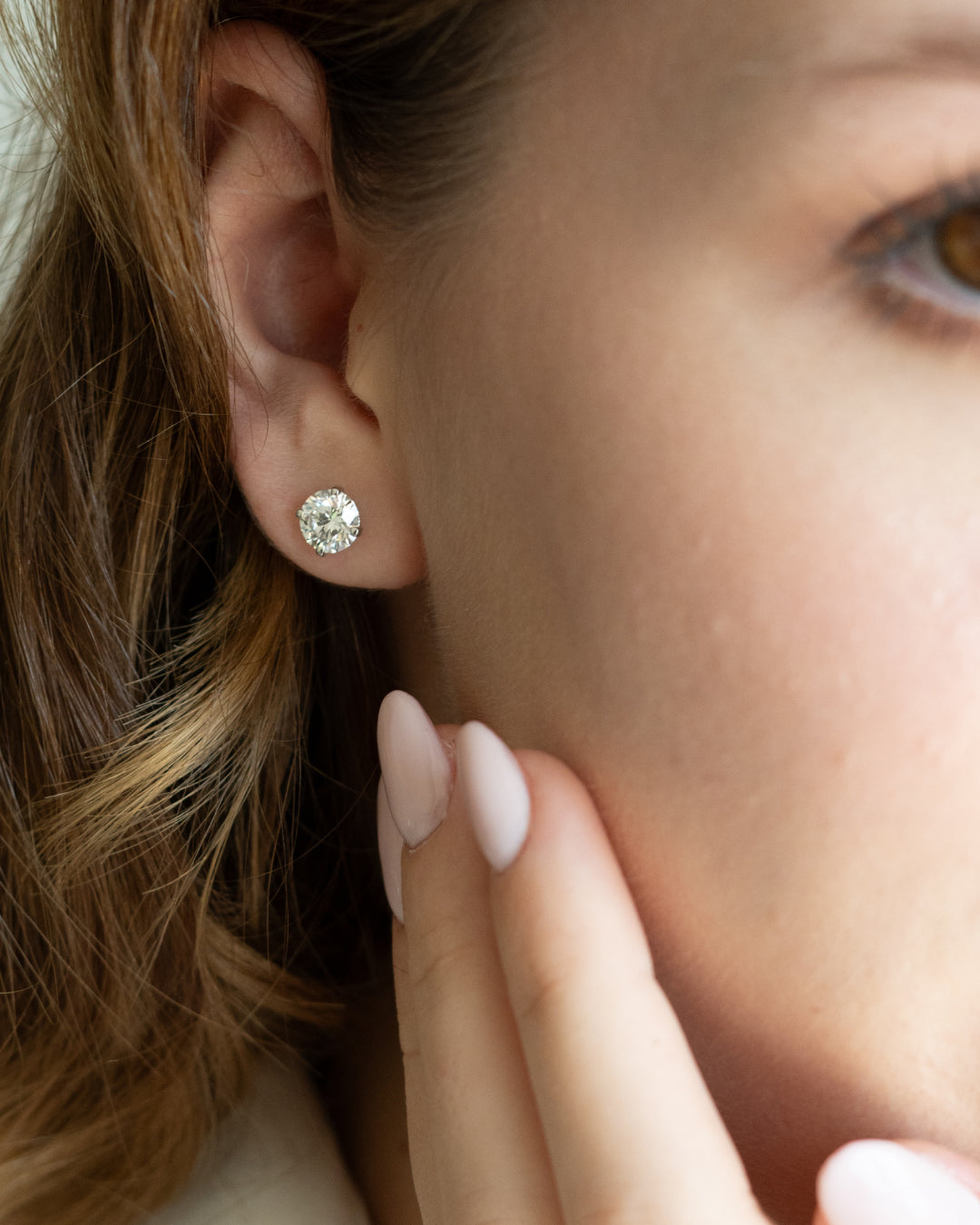 Elegantly displayed certified diamond earrings on a model, showcasing timeless style and brilliance.