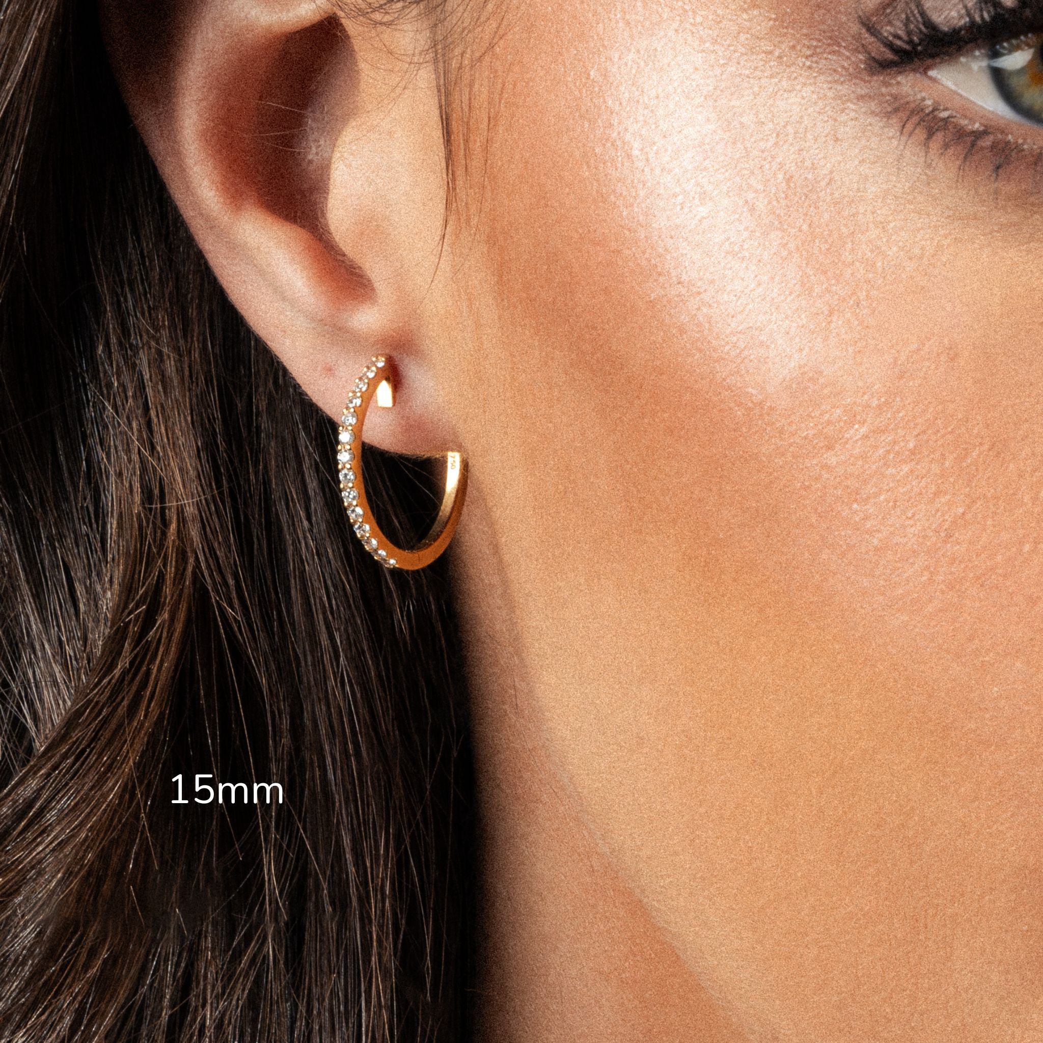 Close-up of a hoop earring showcasing certified diamonds in a gold setting