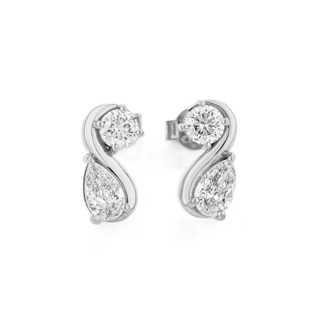 Pair of pear shaped diamond earrings on a white background