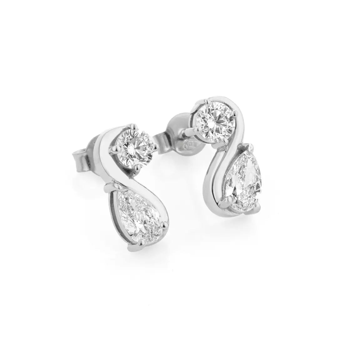 Diamond earrings with pear-shaped and round stones on a white background