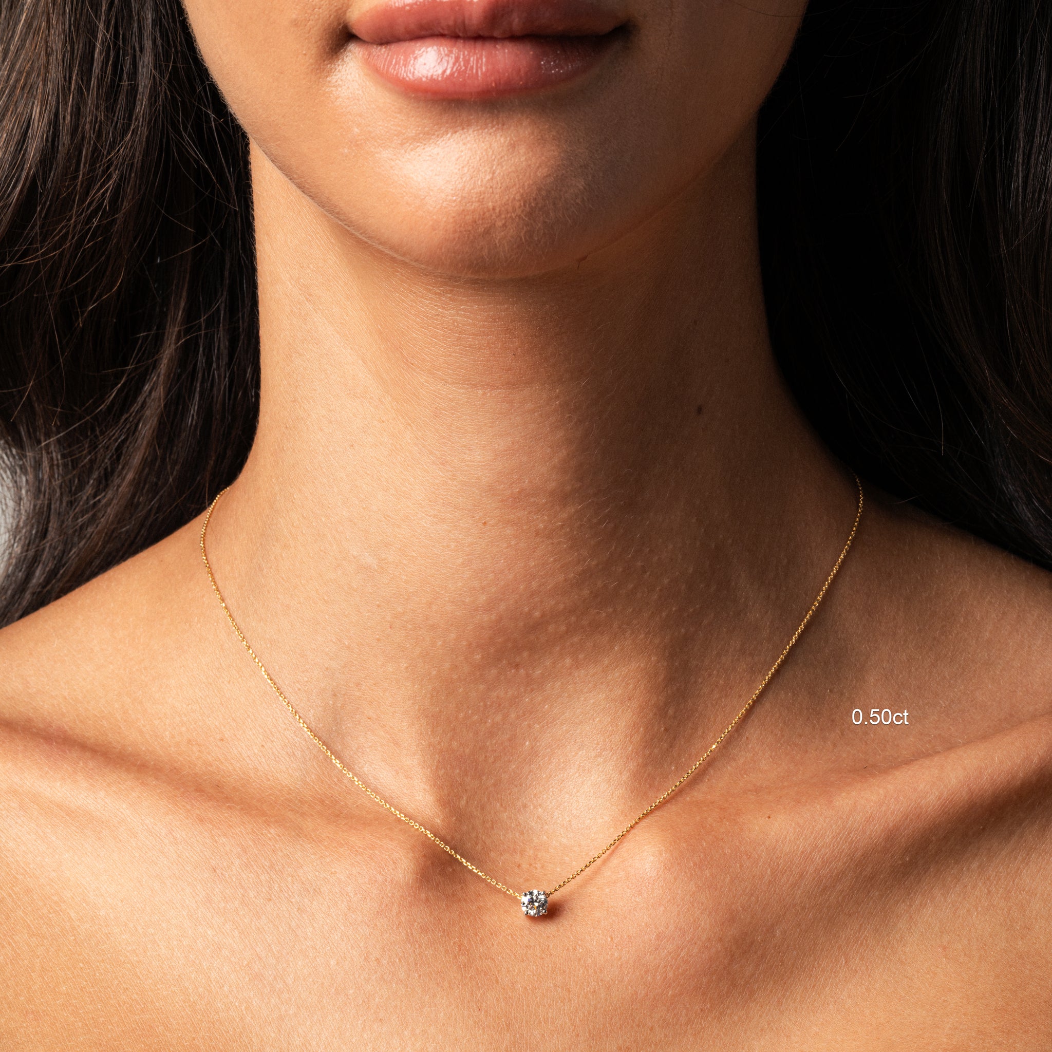 The Floating Diamond Necklace showcased on model, featuring a round diamond on a fine gold chain, highlighting elegant beauty.