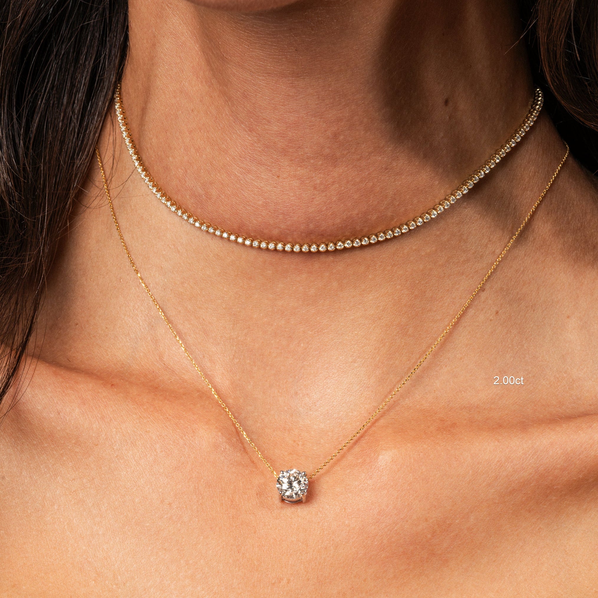 The Floating Diamond Necklace worn elegantly, featuring a round brilliant cut diamond set on a fine gold chain.