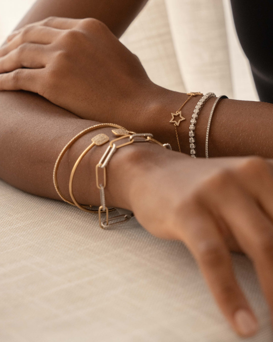 Close-up of a wrist with mixed gold and diamond bangles, showcasing a stylish diamond bangle and diamond bracelet.
