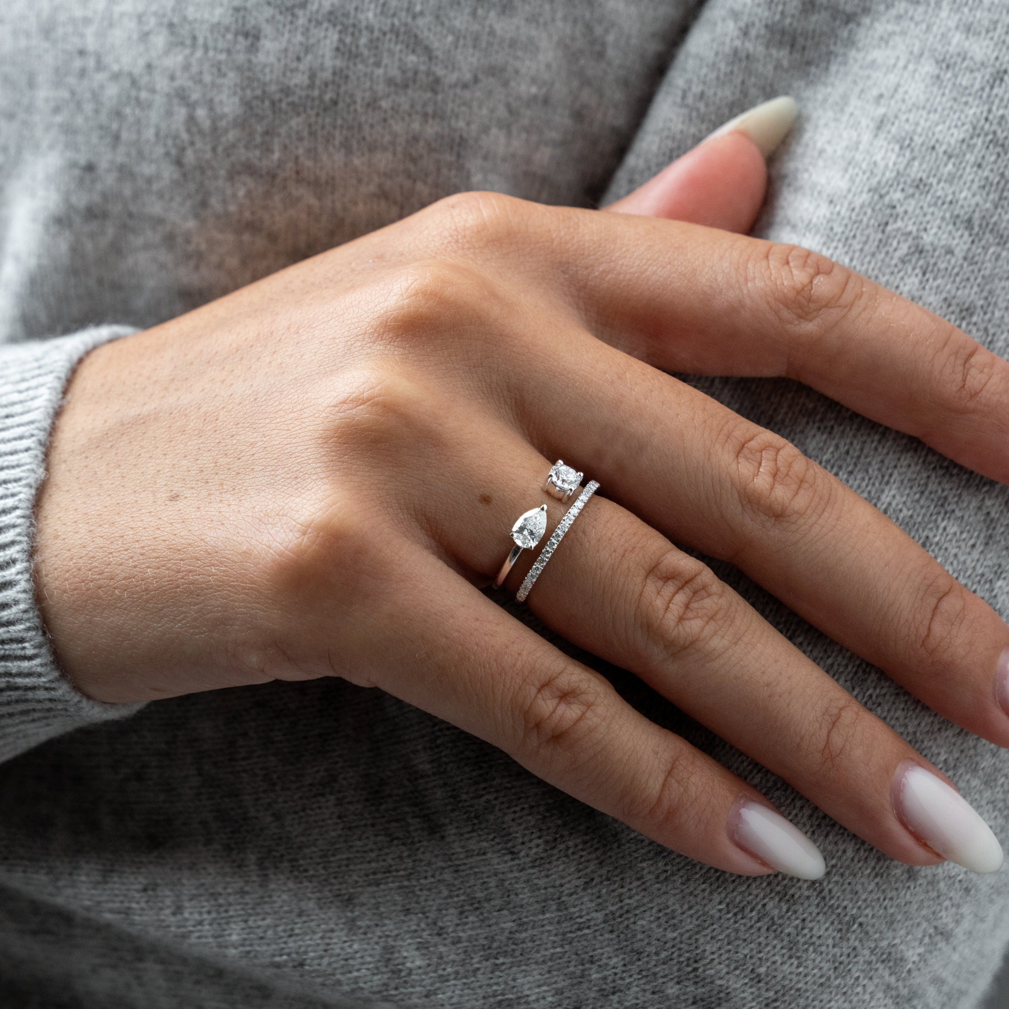 Hand wearing a gemini diamond ring in white gold.