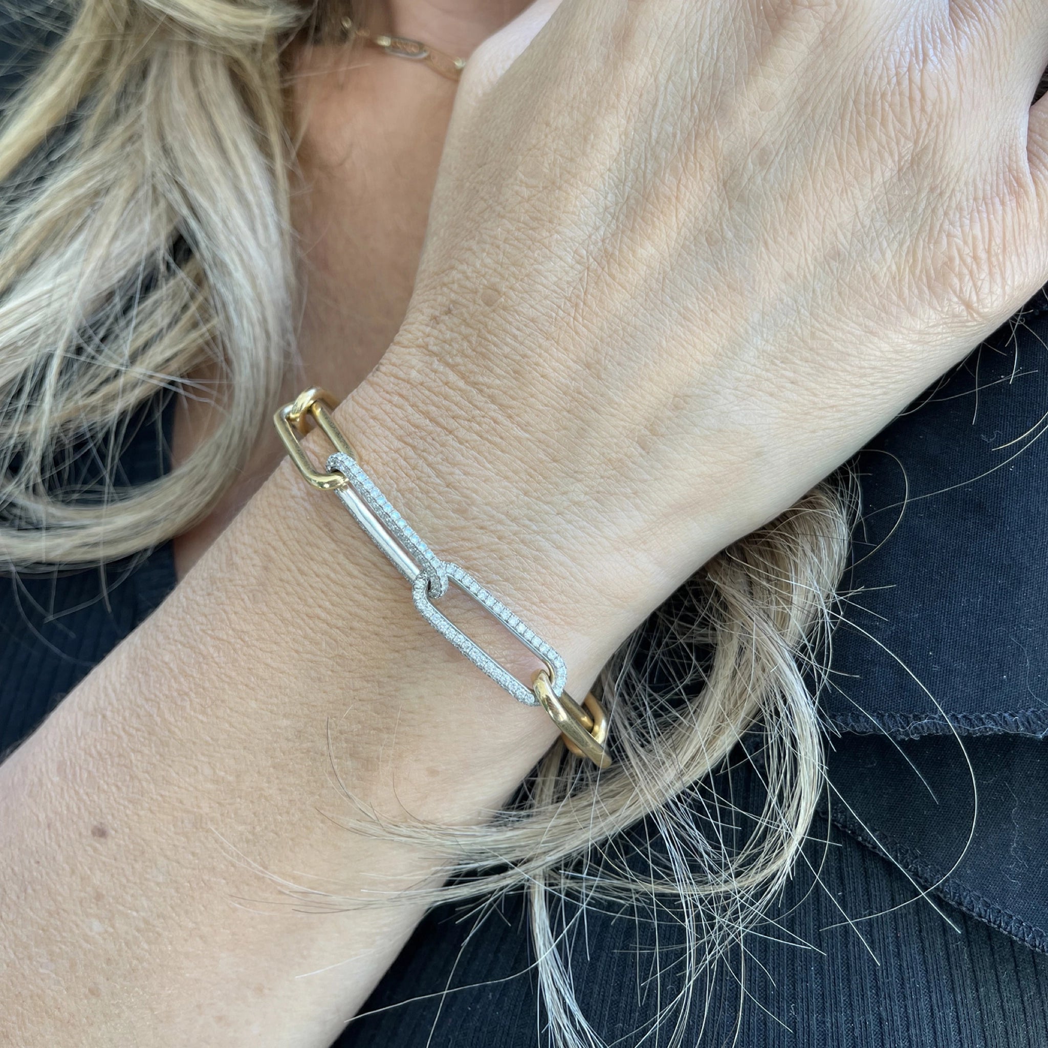 Elegant medium chain link bracelet in yellow and white gold, adorned with sparkling diamonds.