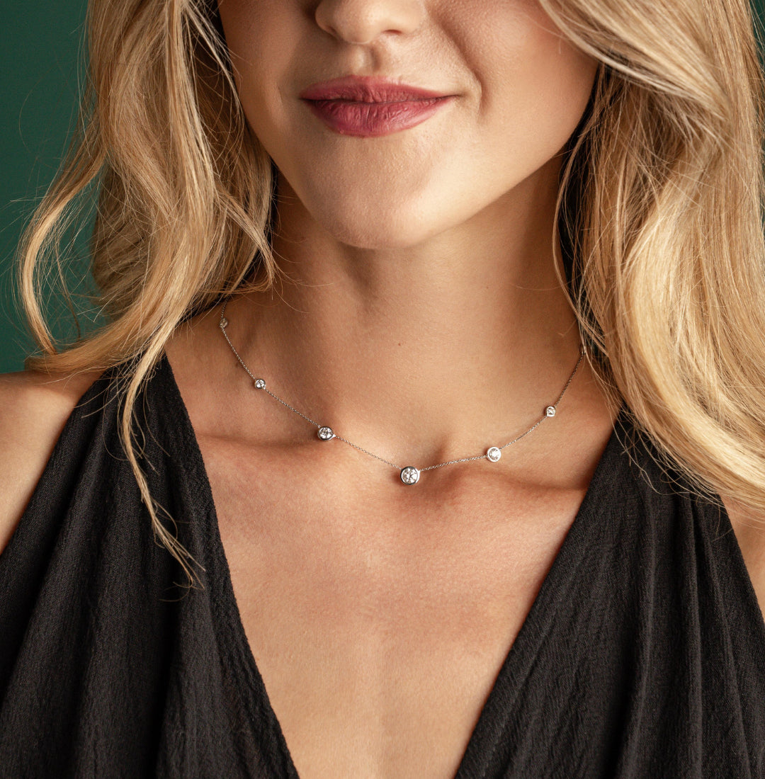 Constellation Necklace - Graduating worn by a model, featuring graduating diamonds in a delicate bezel setting.
