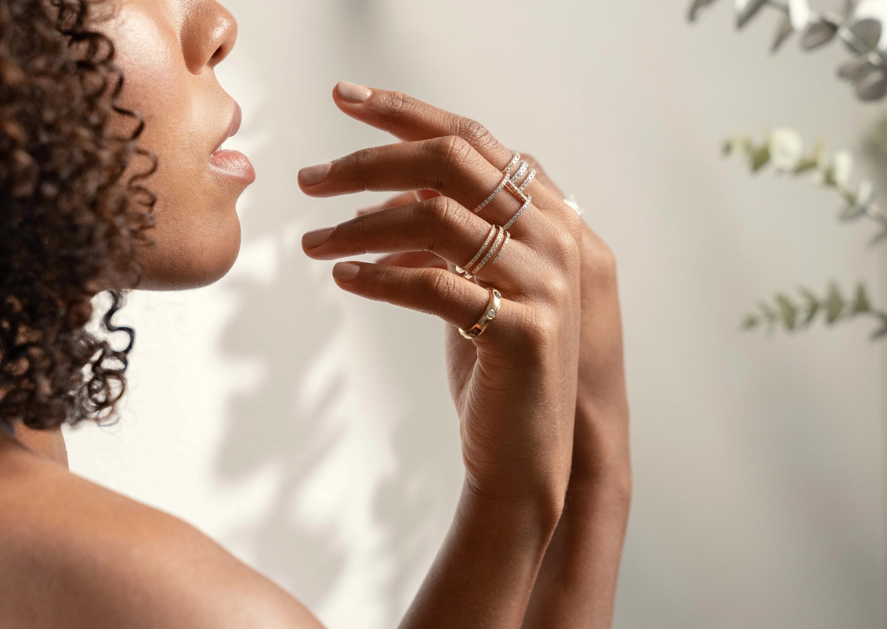 Woman wearing multiple rings on her hand with a blurred background