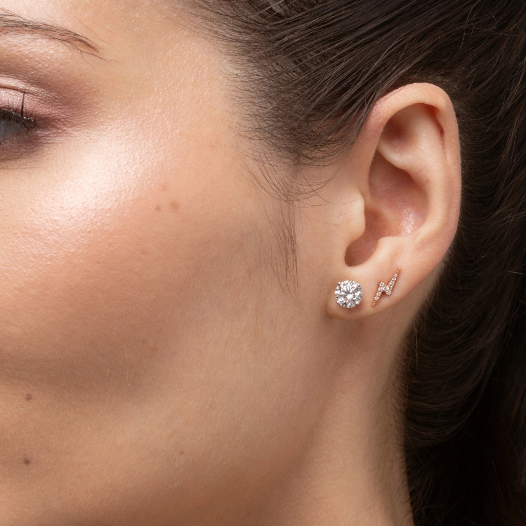 Woman wearing lightning bolt earrings with certified diamonds, showcasing a radiant and elegant style.