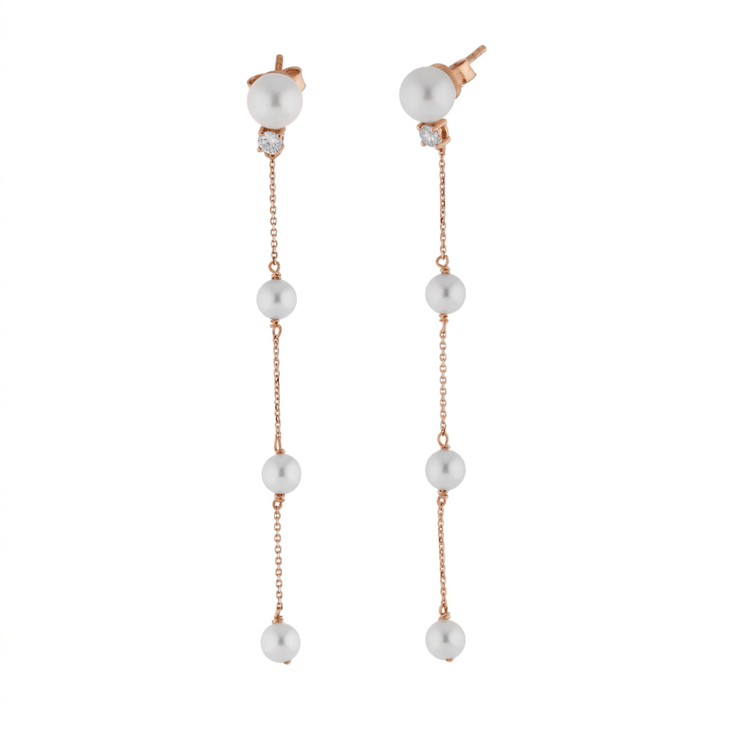 Long pearl drop earring with a single diamond set in 18ct rose gold.