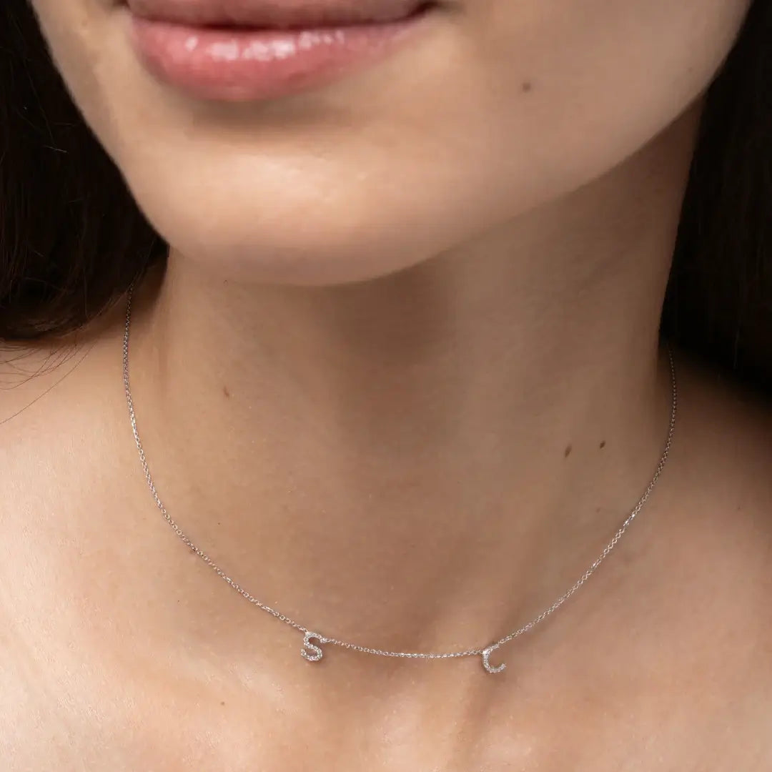 Model wearing a Love Letter necklace with certified natural diamond initials S and C on a fine link chain.