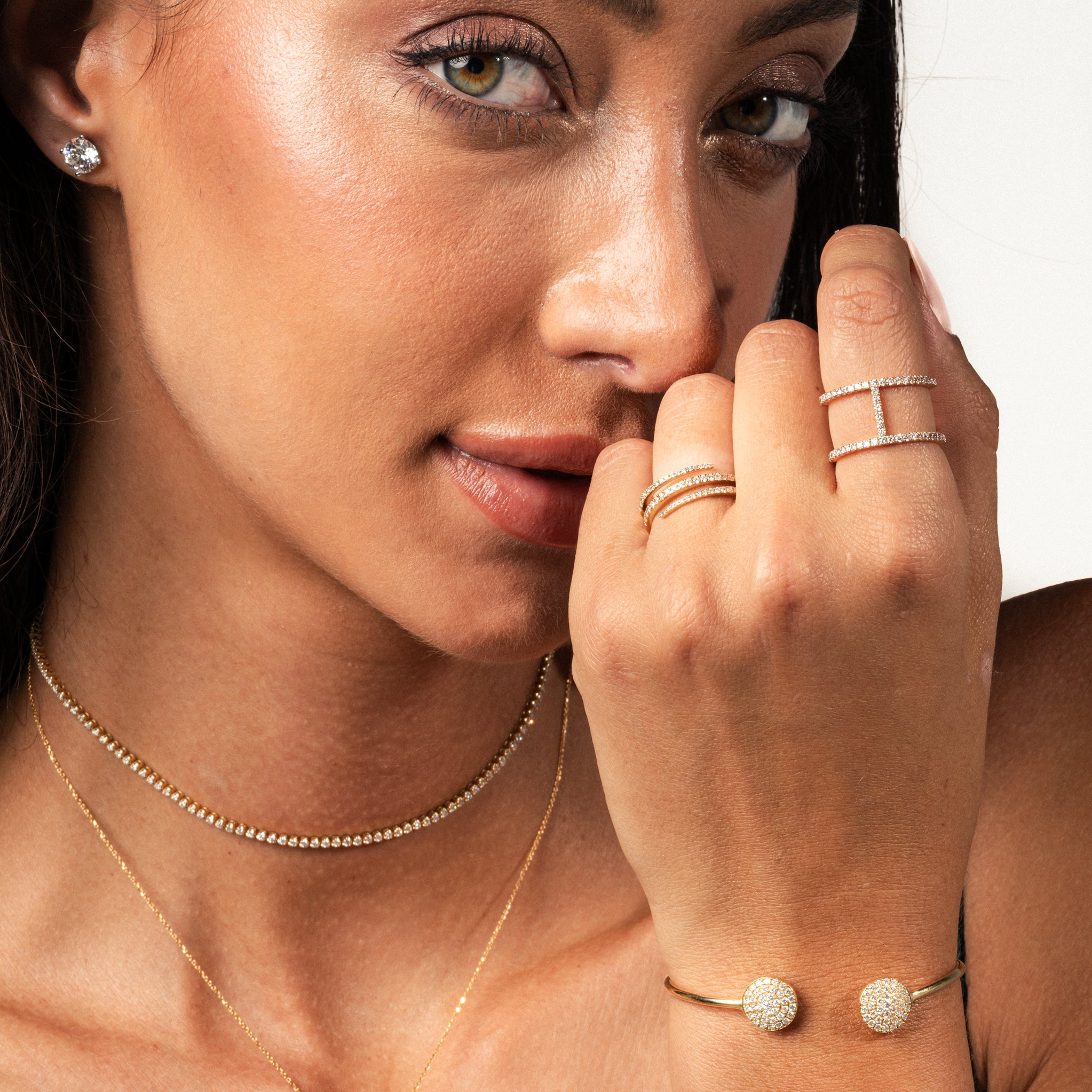 Close-up of a woman wearing a certified diamond necklace and rings, showcasing luxurious jewellery pieces.