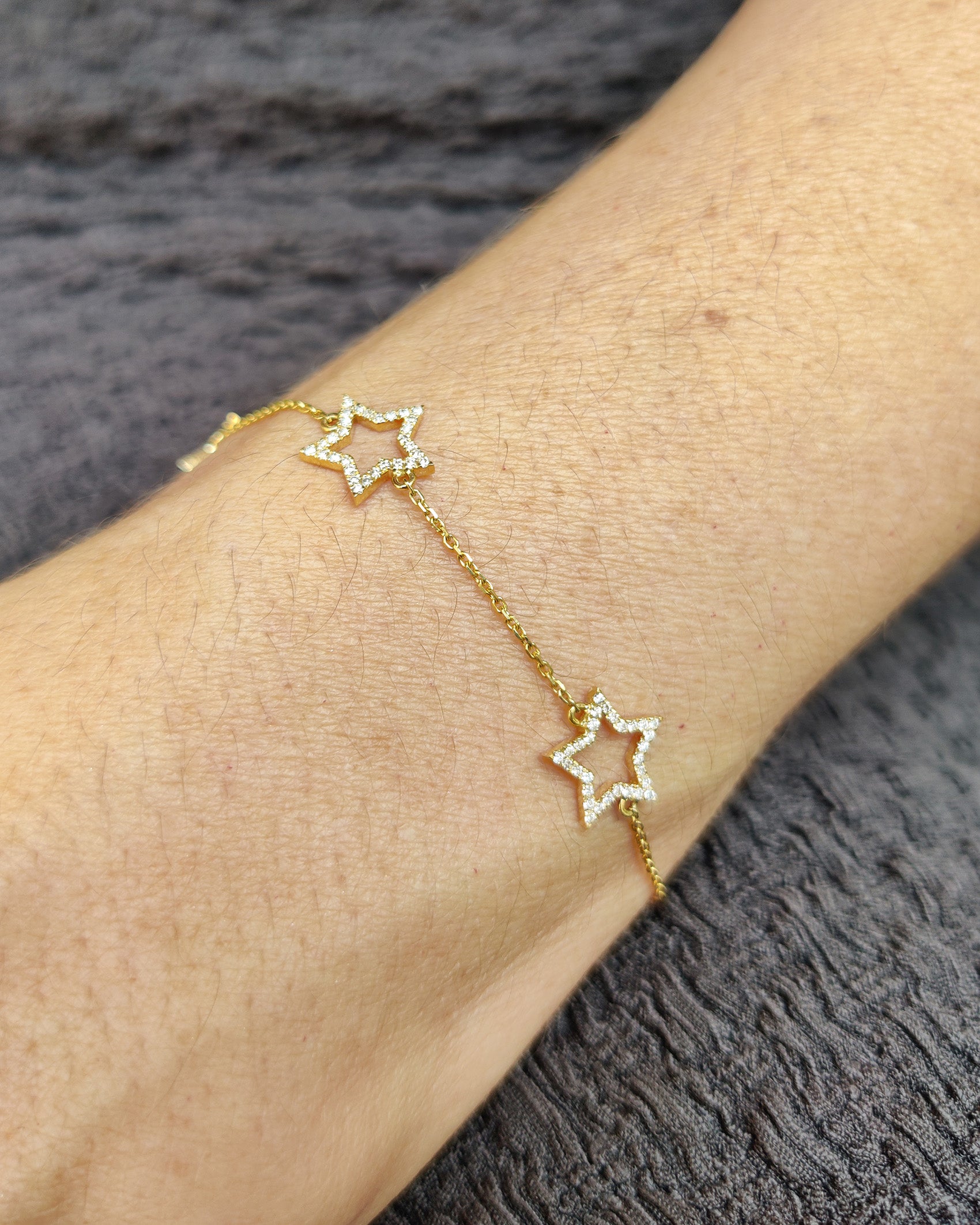 Star bracelet featuring diamond-set motifs on a delicate gold chain, perfect for a feminine and youthful style.