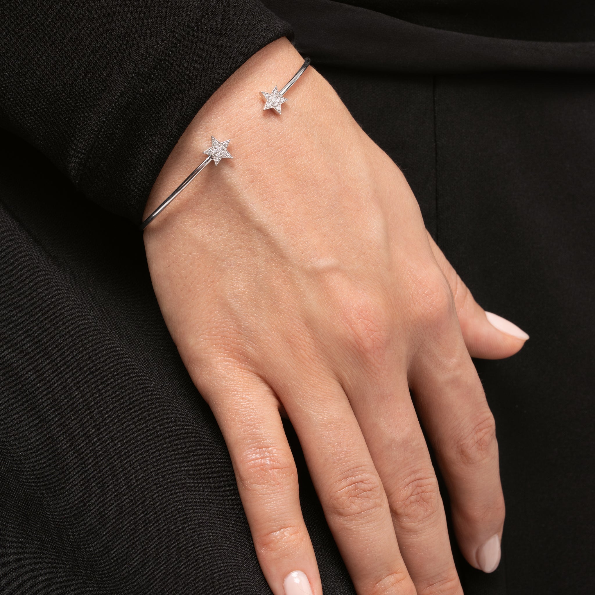Star bangle on a woman's wrist showcasing certified diamond bracelet in elegant design.