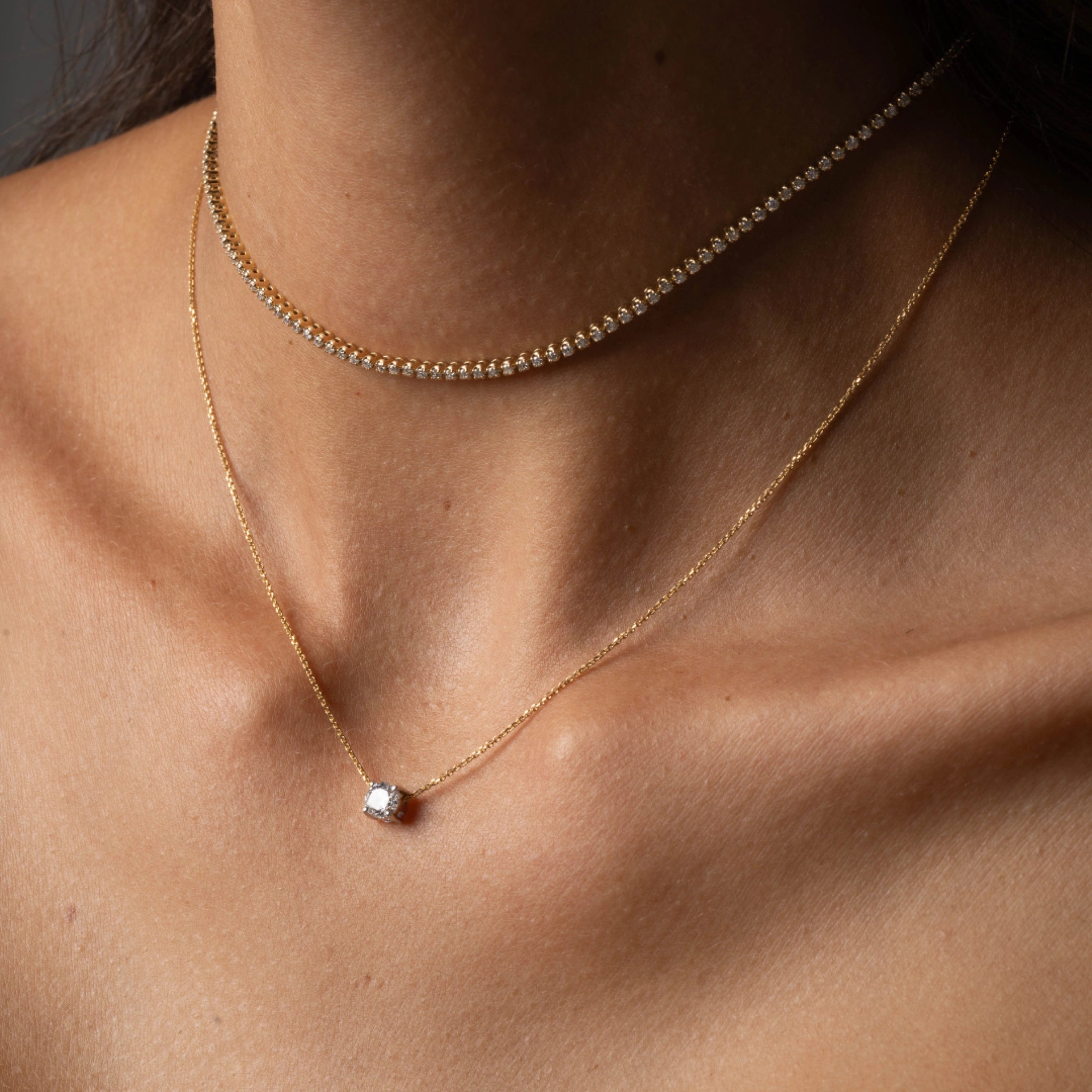 The Floating Diamond Necklace worn elegantly, featuring a round brilliant cut diamond set on a fine gold chain.