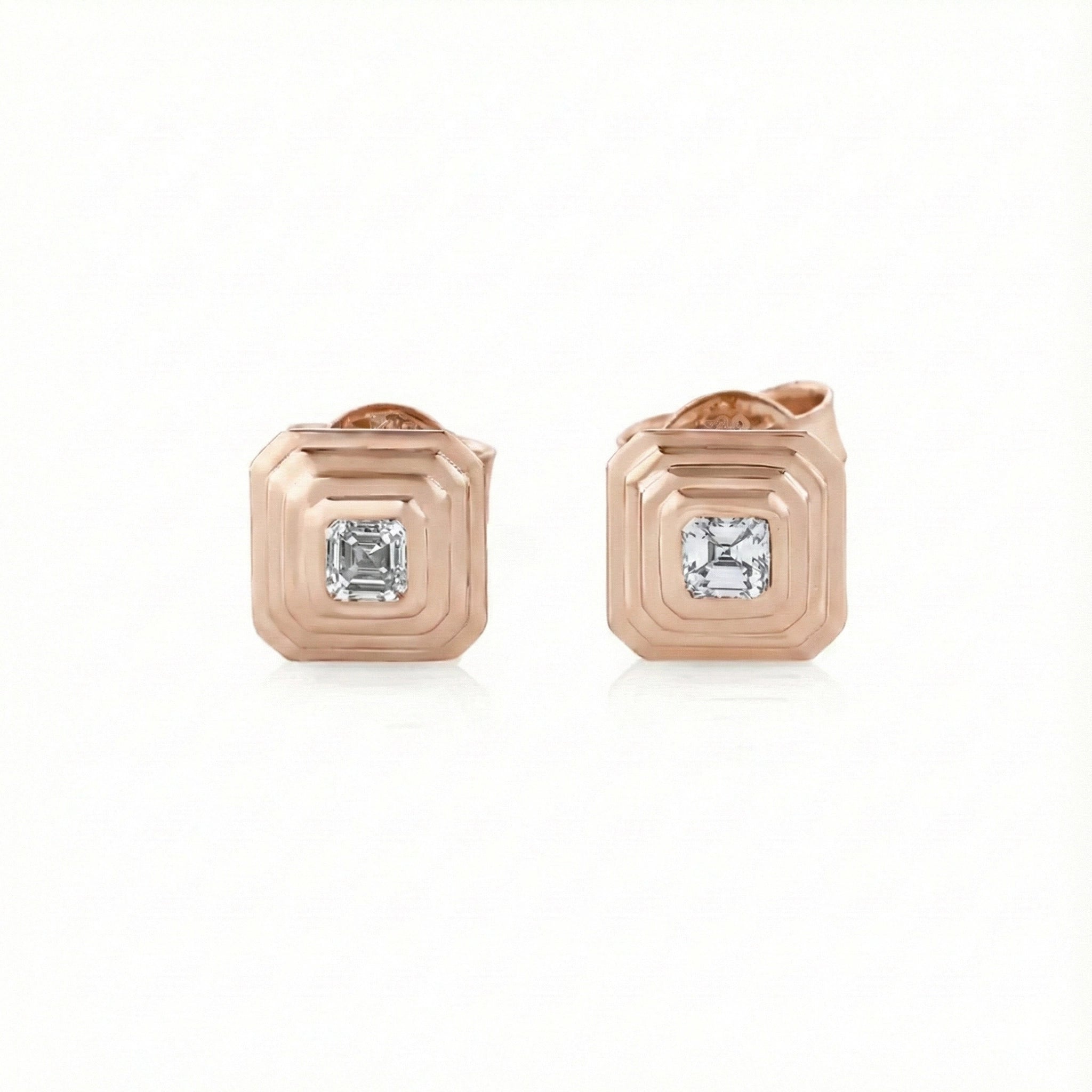 Rose gold earrings with asscher cut diamonds on a white background