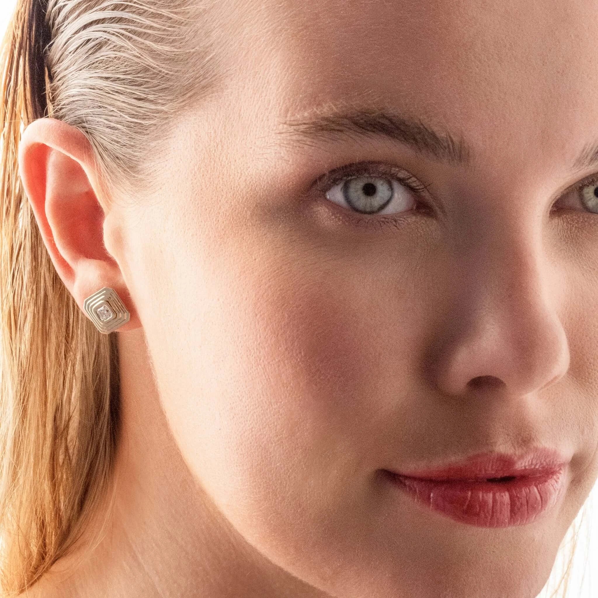Close-up of a woman's face with a focus on her diamond earring.