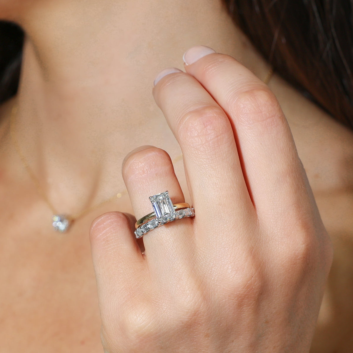 End to End Emerald Cut Diamond Ring worn on a hand featuring stunning diamond and gold design.