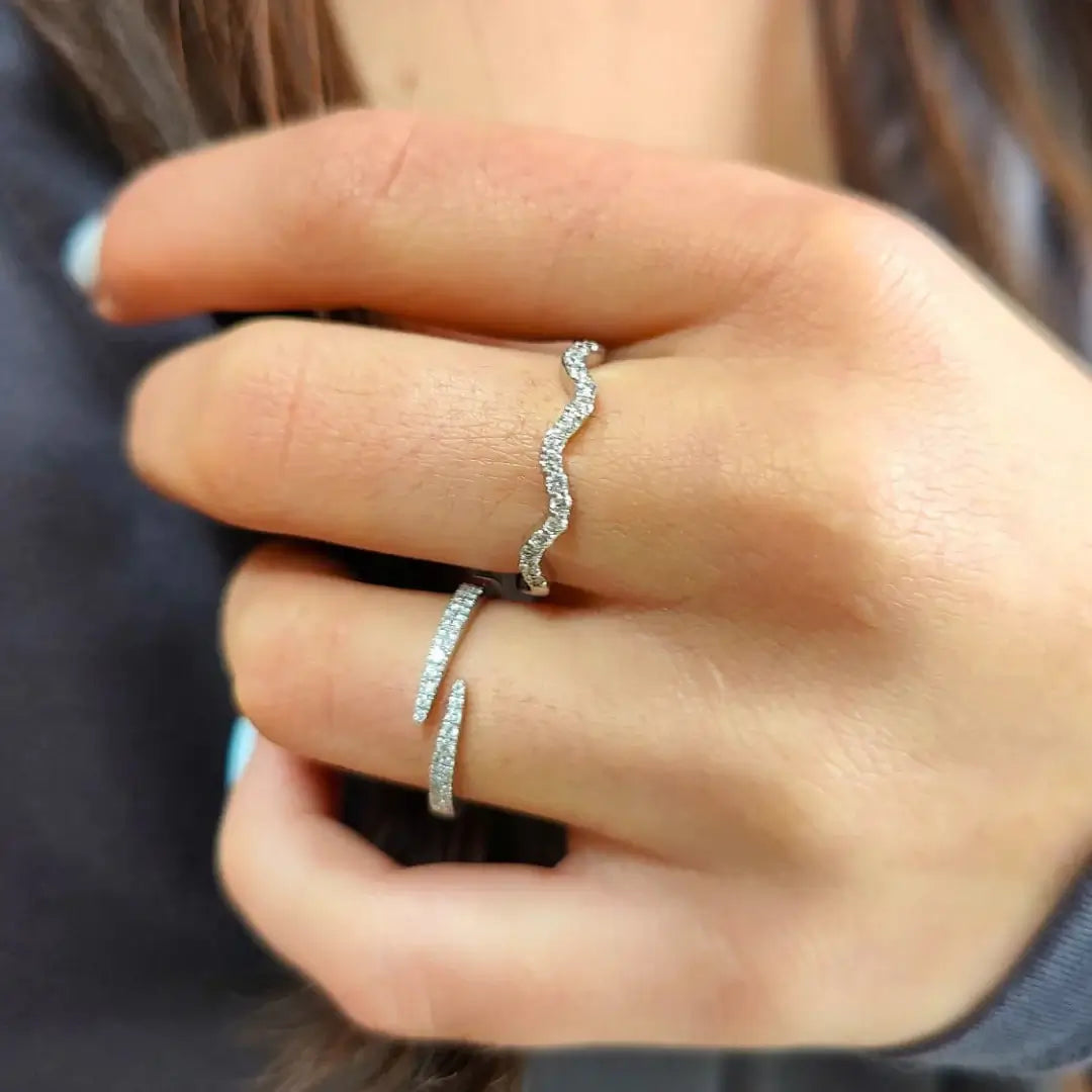 Close-up of a hand wearing two diamond rings with a blurred background