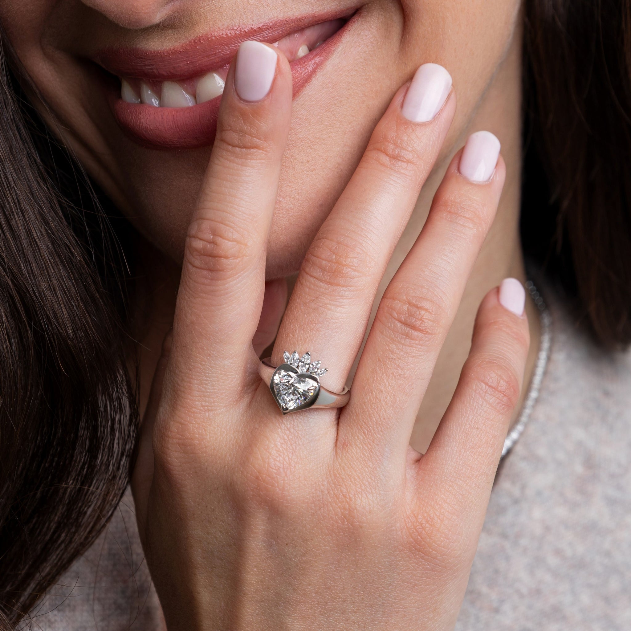 Close-up of a hand wearing a claddagh ring with heart shaped diamond