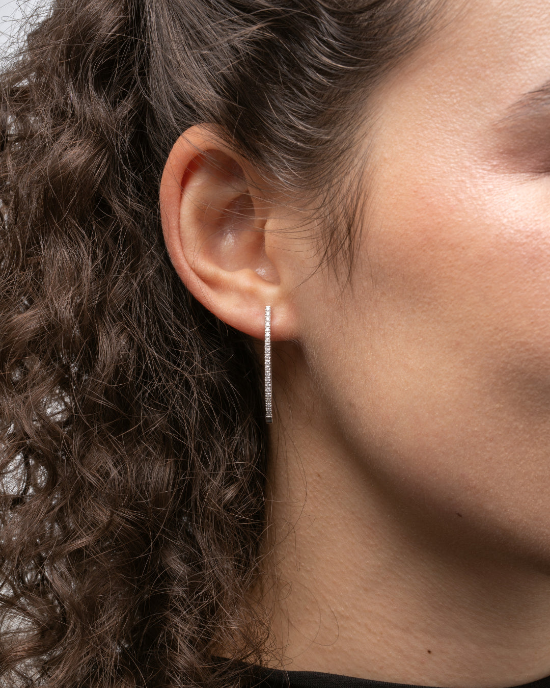 Modern V-shaped certified diamond earrings in elegant 18ct gold, complementing facial features.