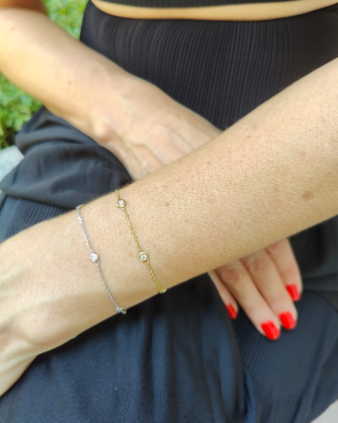 Feminine wrist adorned with a certified diamond bracelet and diamond bangle in gold and silver settings.