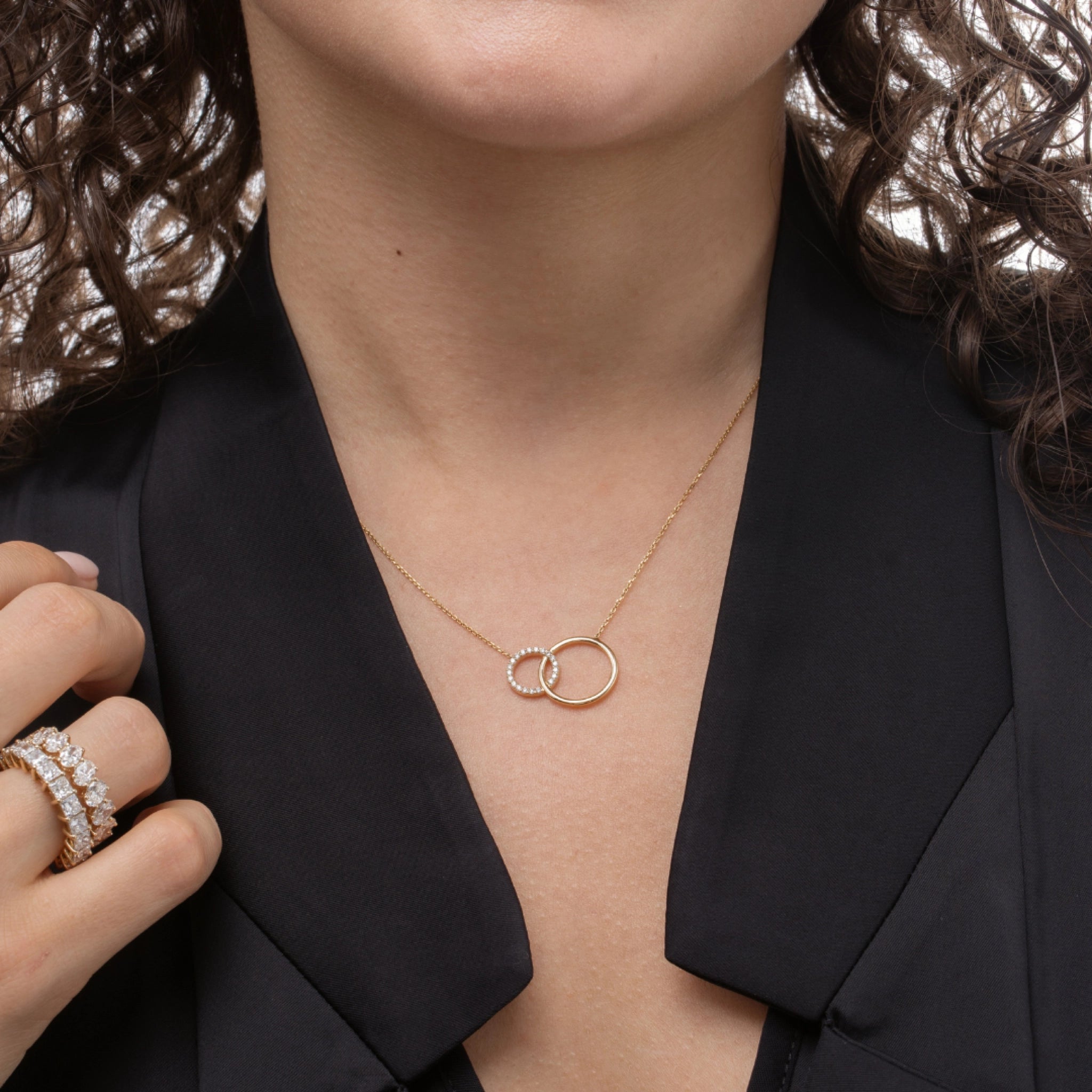Woman wearing a certified diamond necklace featuring interlocking circles, showcasing sparkling diamonds.