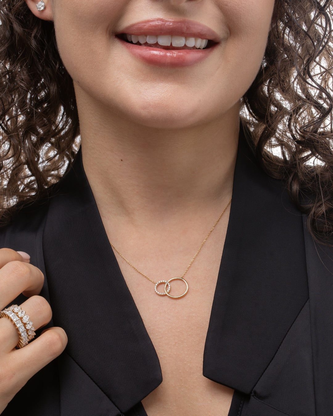 Woman wearing a certified diamond necklace featuring interlocking circles, showcasing sparkling diamonds.