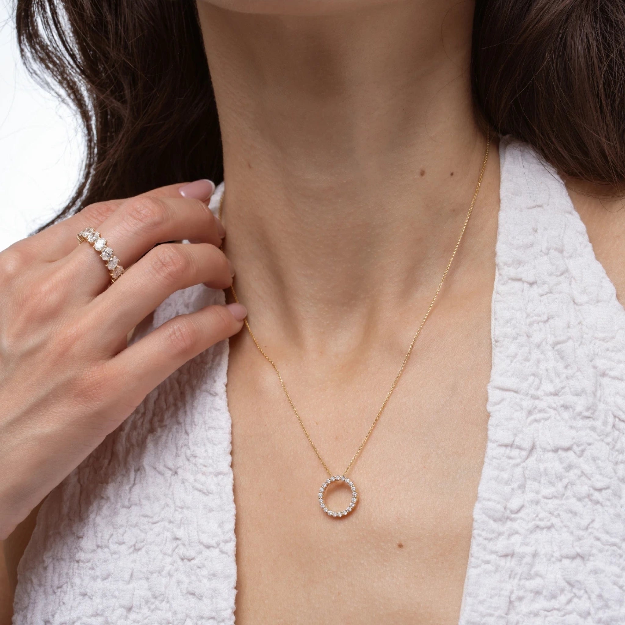 Woman wearing a Circle Of Life Necklace - Small with diamonds, showcasing its elegance and sparkle.