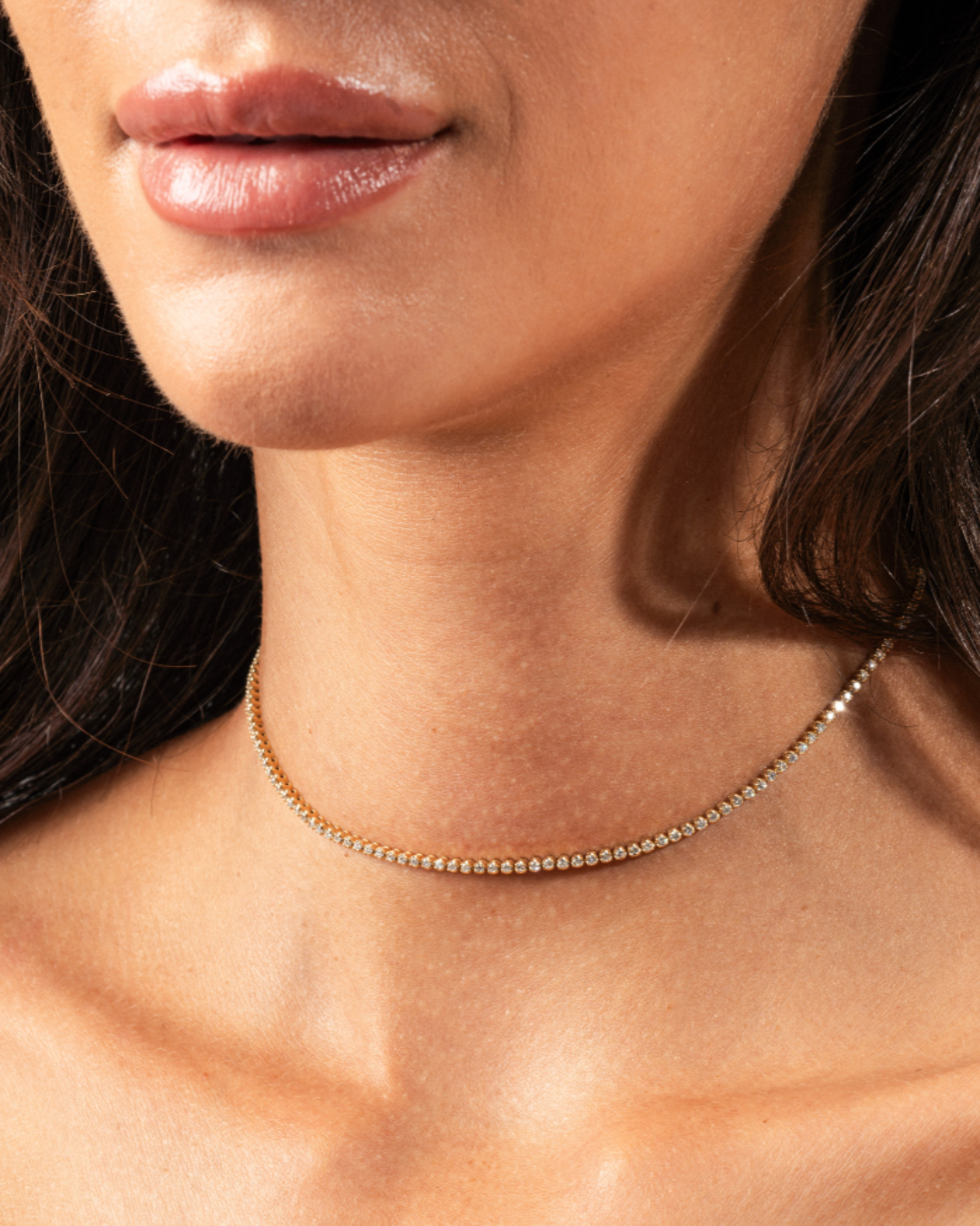 Close-up of a woman wearing a Maia certified diamond necklace showcasing round brilliant cut diamonds.