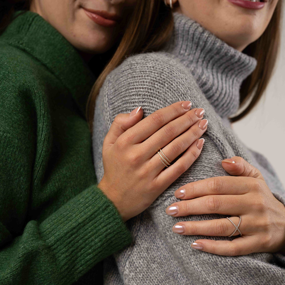 Models wearing ciss-cross rings with round brilliant cut diamonds, white gold colour set in 18ct gold.