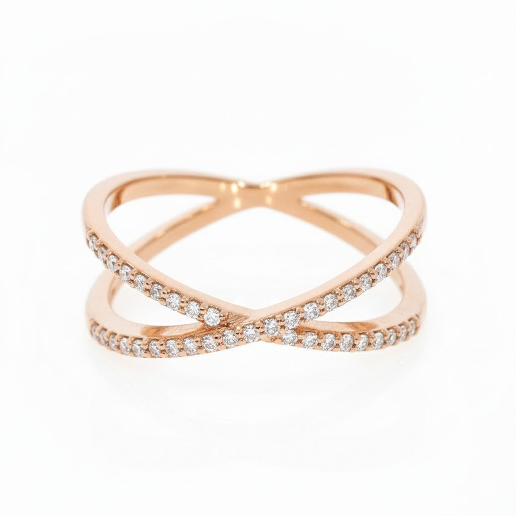 Rose gold criss cross ring with diamonds on a white background
