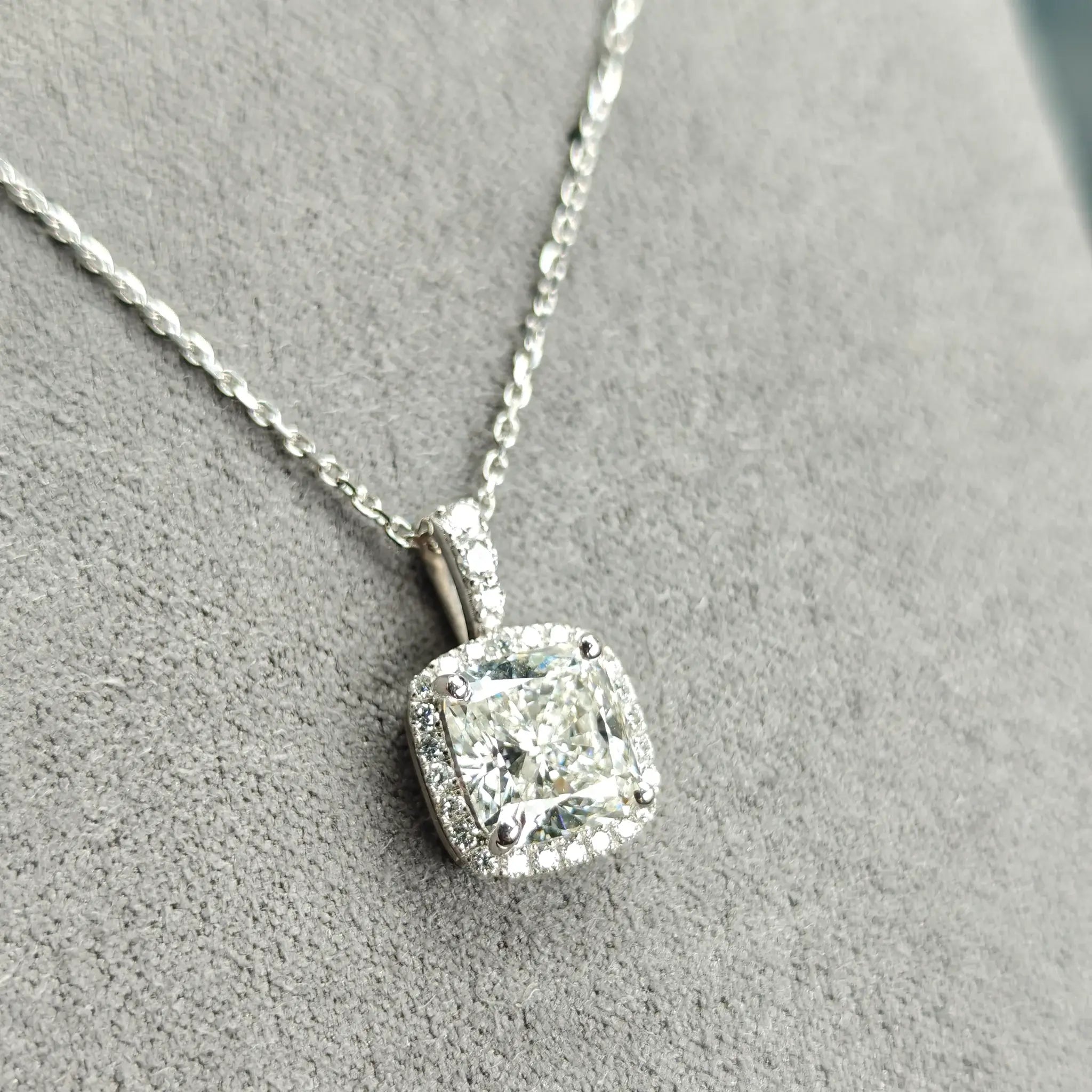 White gold diamond necklace on a gray surface