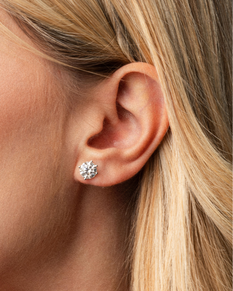Close-up of a woman wearing certified diamond earrings showcasing their brilliance.