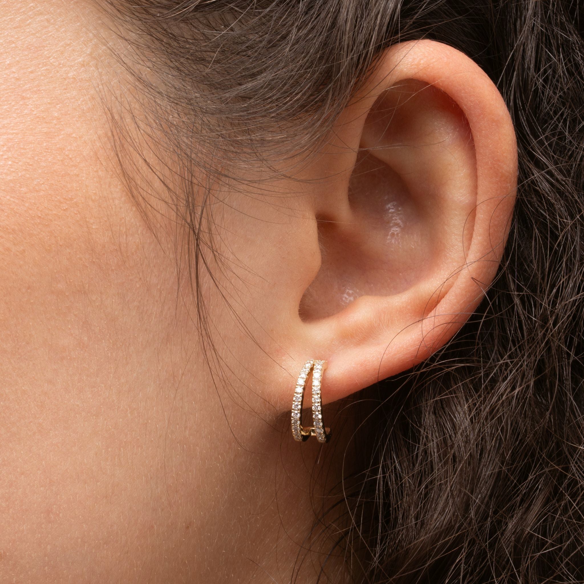 Close up of model wearing double row diamond huggies showcasing certified diamond earrings in 18ct gold.
