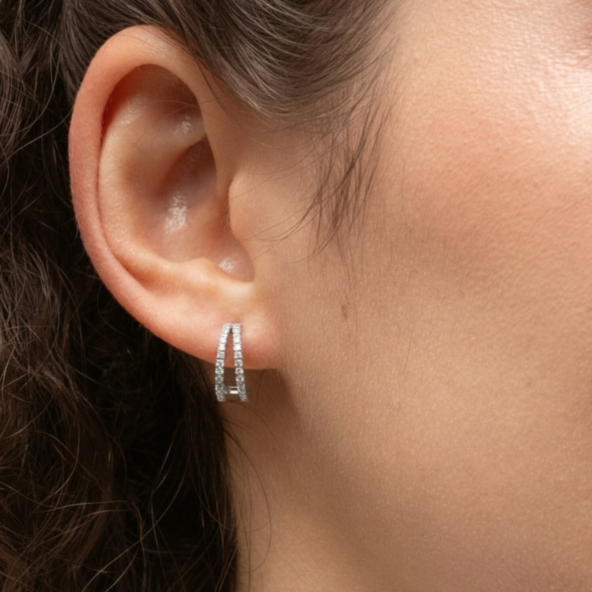 Close-up of an ear wearing a diamond hoop earring