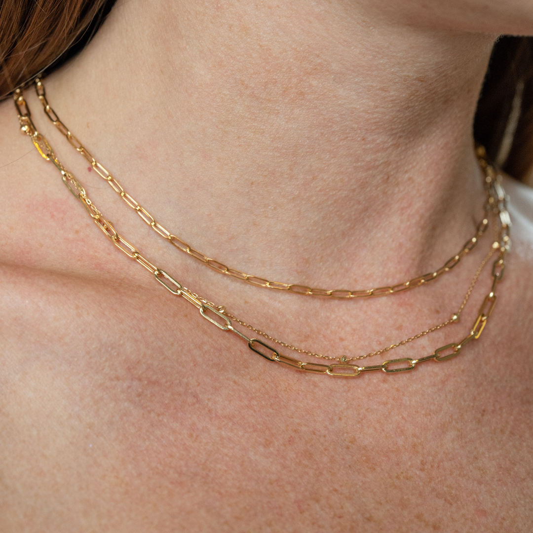 18ct gold link necklace displayed elegantly layered on the neck, showcasing its luxurious design and quality.