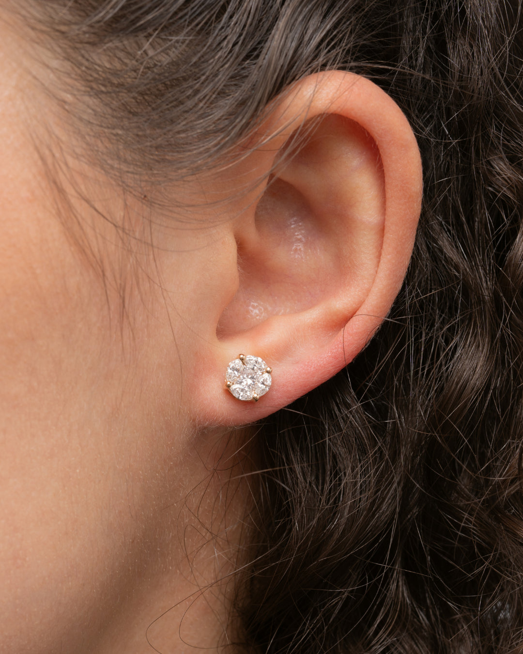 Close-up of a model wearing illusion stud earrings made with certified diamond earrings for an elegant look.