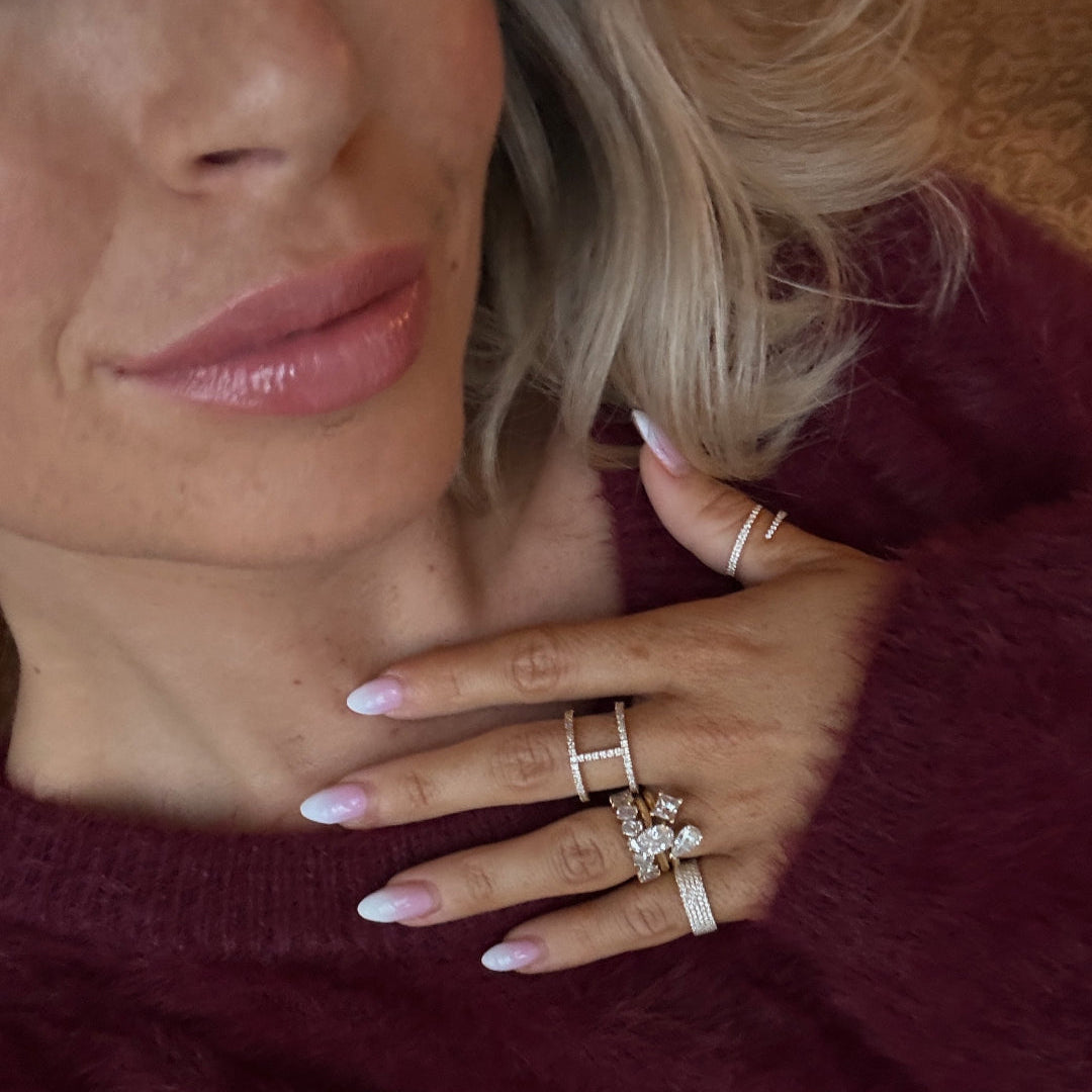 Close-up of a woman wearing multiple diamond rings on her fingers, showcasing modern luxury and style.