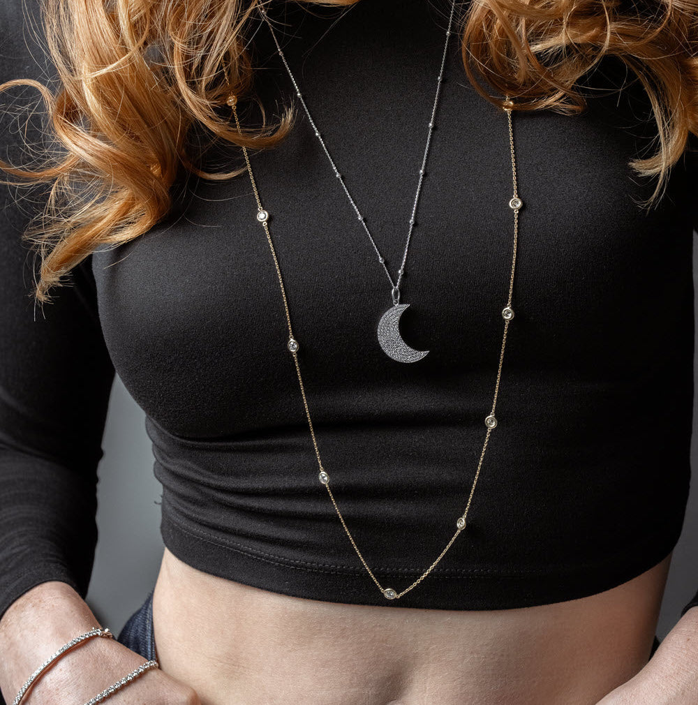 Model wearing Long Constellation Necklace and Long Moon necklace, showcasing elegant diamond jewelry.